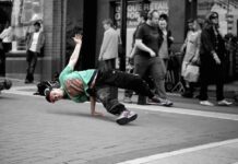 Sammenhængen mellem tøj og musik Break dancer danser på asfalt på gaden