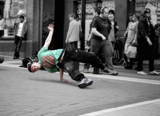 Sammenhængen mellem tøj og musik Break dancer danser på asfalt på gaden